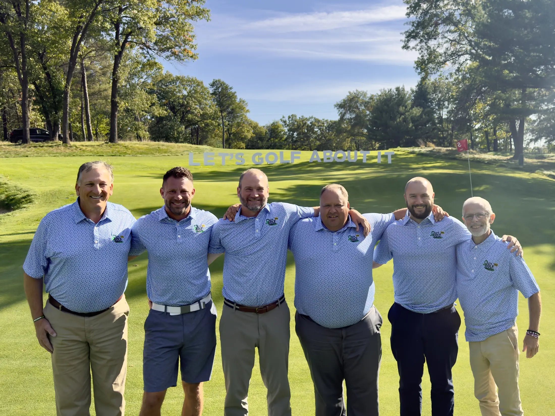 Let’s Golf About It members standing together at a community golf event